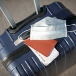 suitcase, passport and medical mask